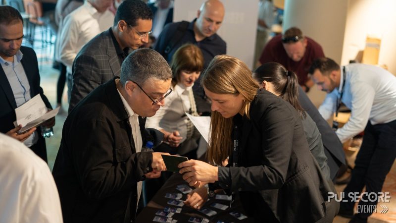 Delegates gather around an exhibitor table at a previous PulseCore event